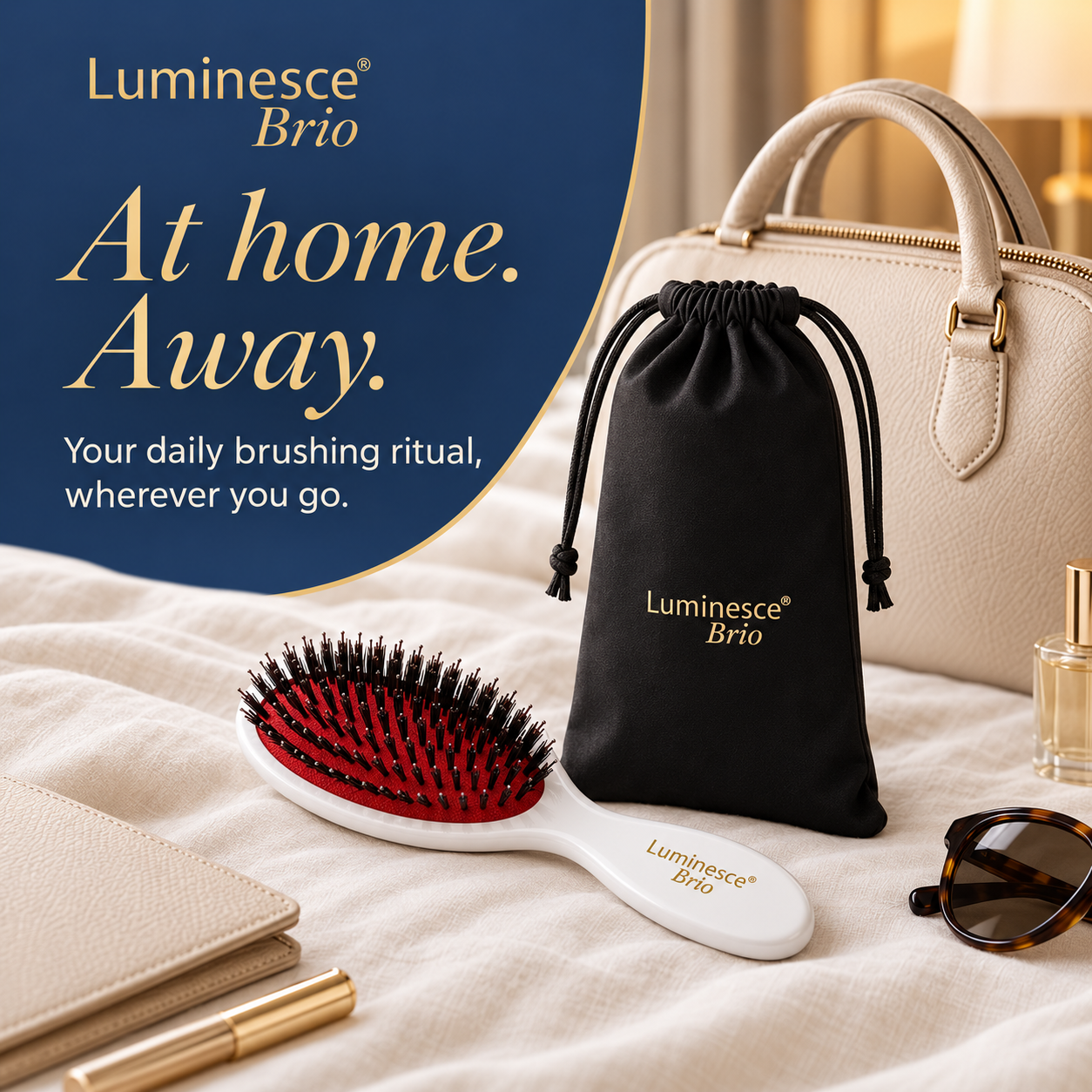 Luminesce Brio brush and travel pouch styled on a bed with a handbag